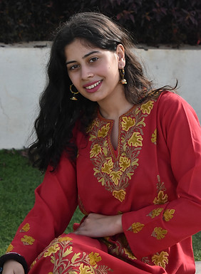 Meta Description for Images: “A portrait of the founder of Koor Kashmir wearing a red Kashmiri embroidered kurti, embodying t