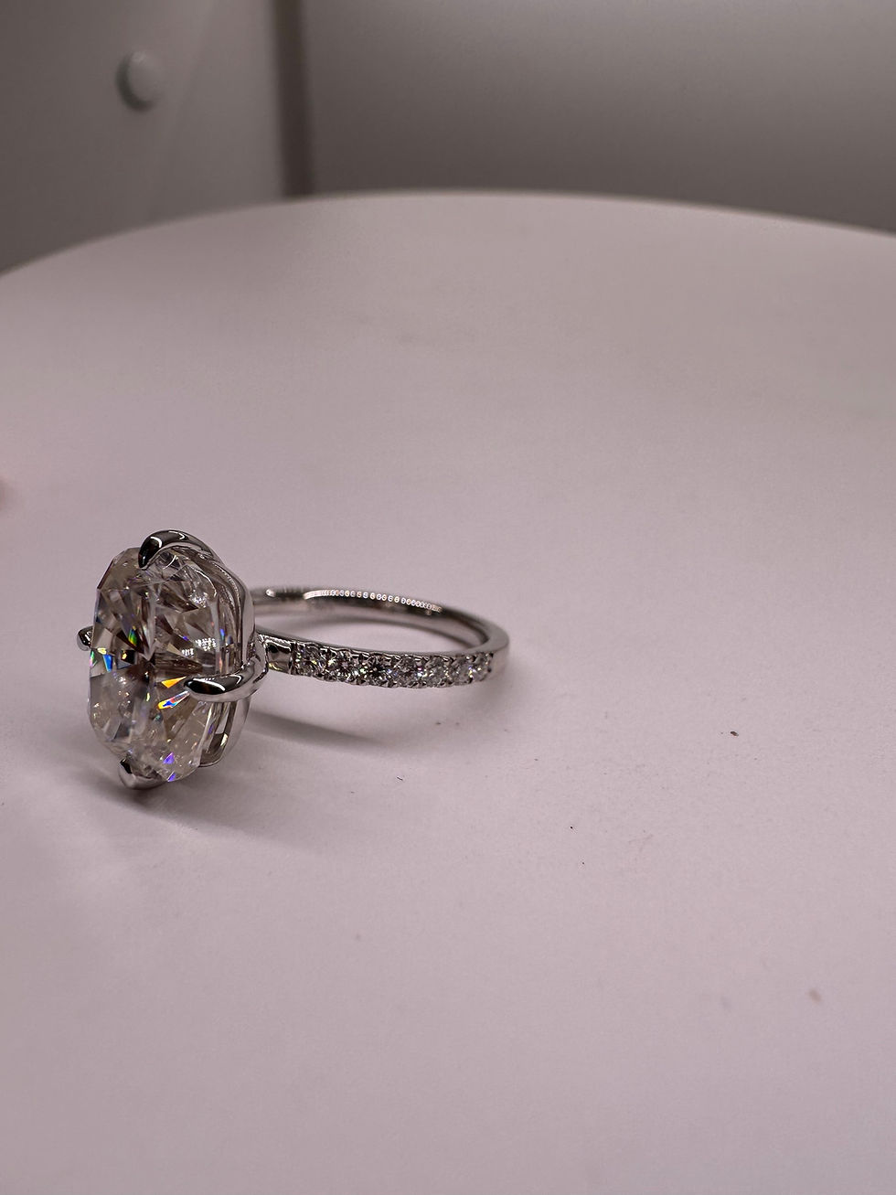 Thumbnail: 4.5 carat cushion moissanite with compass prongs on a pavé band 