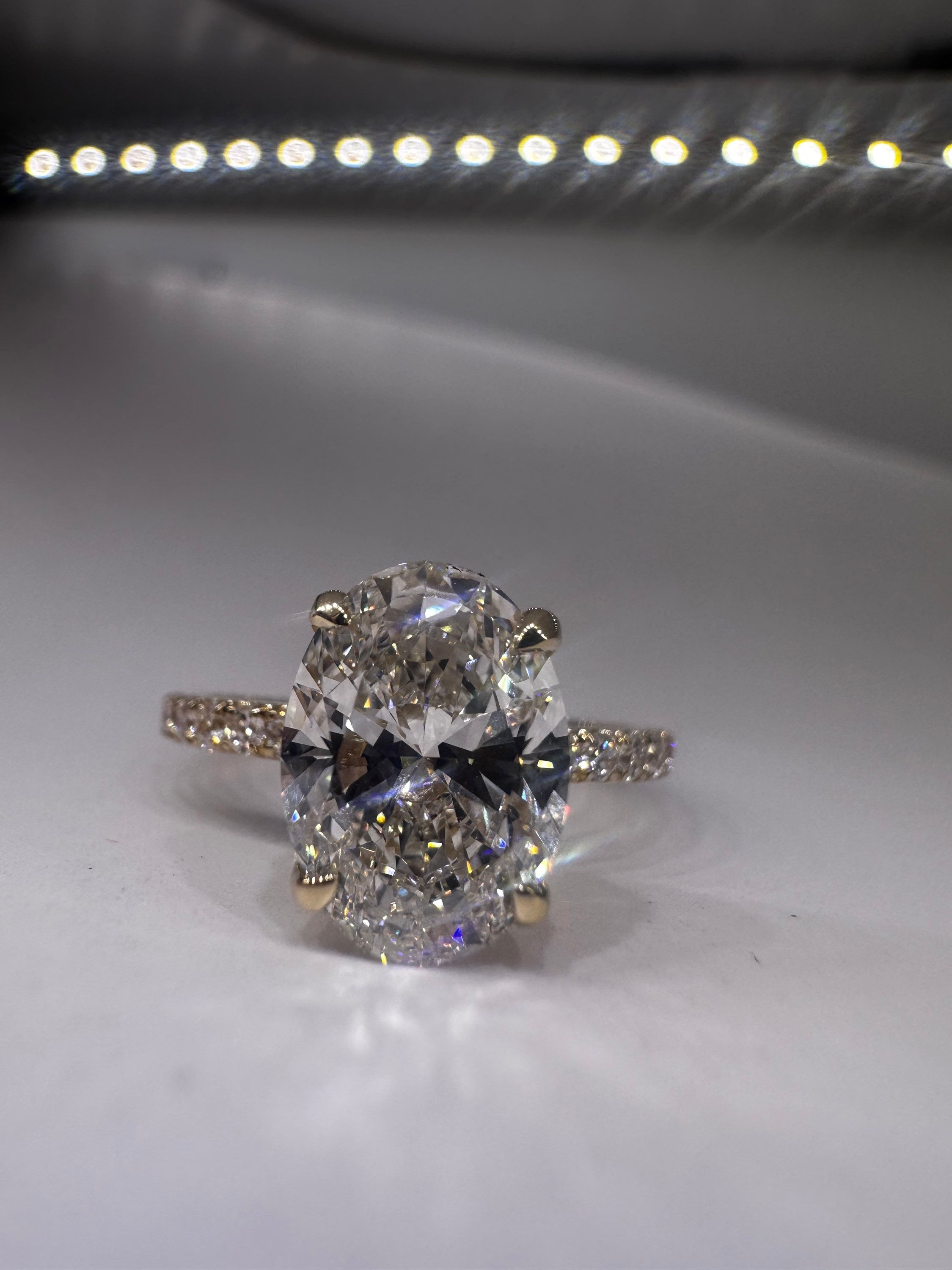 2.08 carat F VVS2 oval lab diamond on a pavé band 14k yellow gold