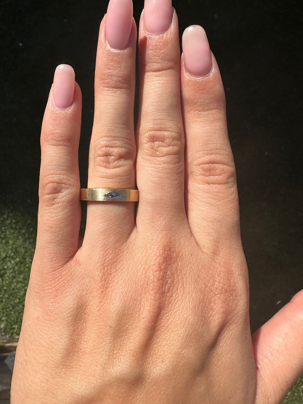 Thumbnail: East west lozenge blue sapphire on a brushed gold 4mm band 