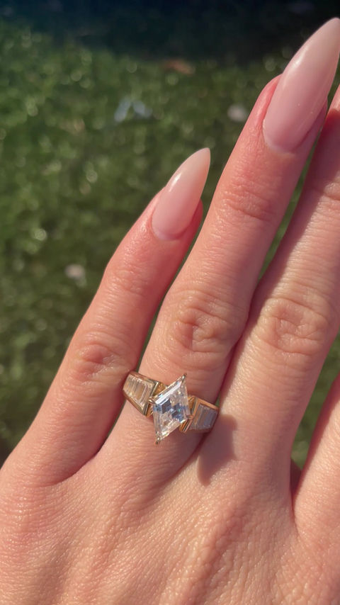 Thumbnail: 2 carat rhombus moissanite in a wide channel set baguette band 