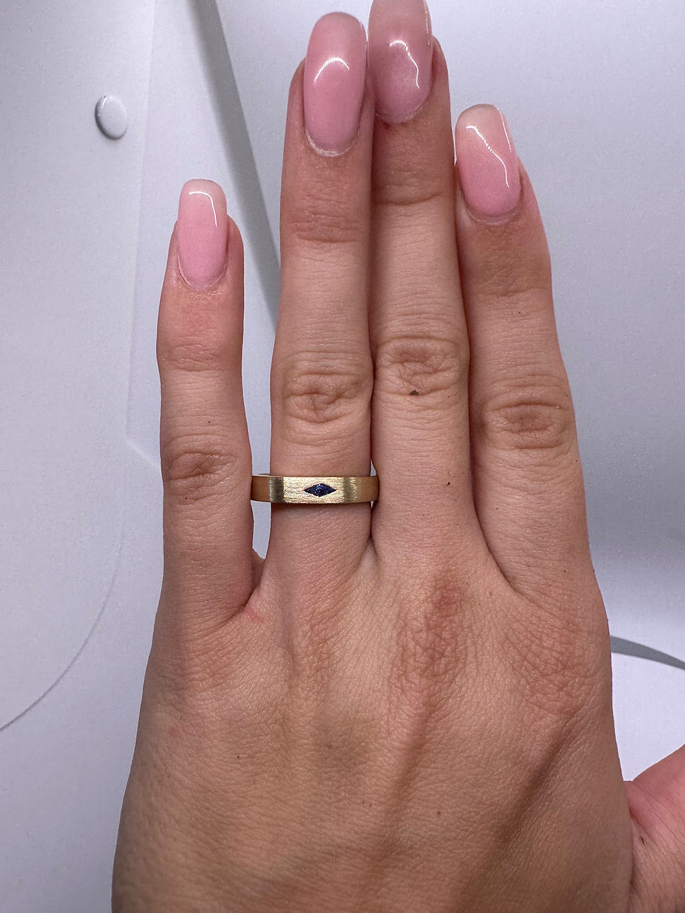 Thumbnail: East west lozenge blue sapphire on a brushed gold 4mm band 