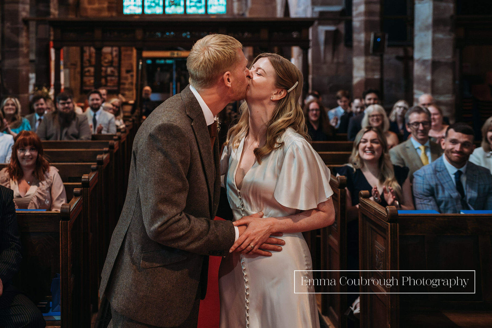 Bride and groom first kiss in audlem church