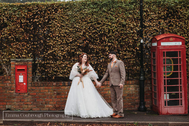 bride and groom by red phonebox