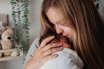 Mum kissing newborn baby