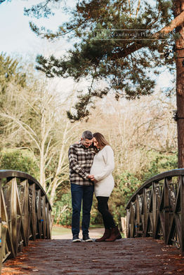 Couple posing for maternity photos on bridge at Tatton Park