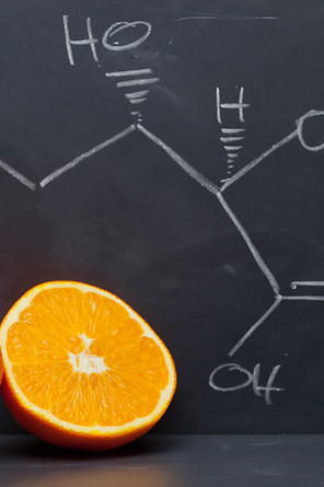 Structural formula of vitamin C on blackboard with orange.jpg