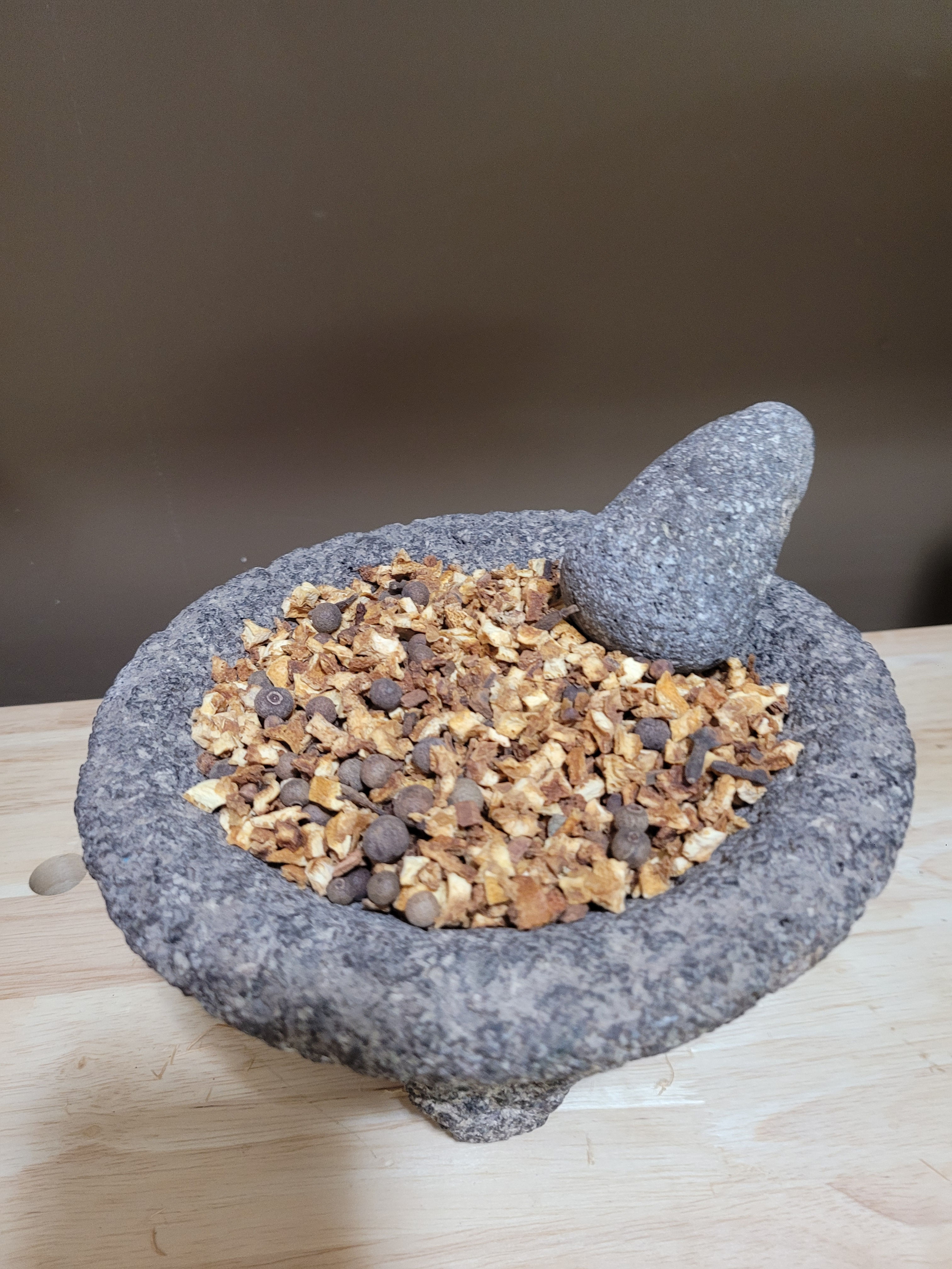 Holiday mulling spice in a stone mortar and pestle.