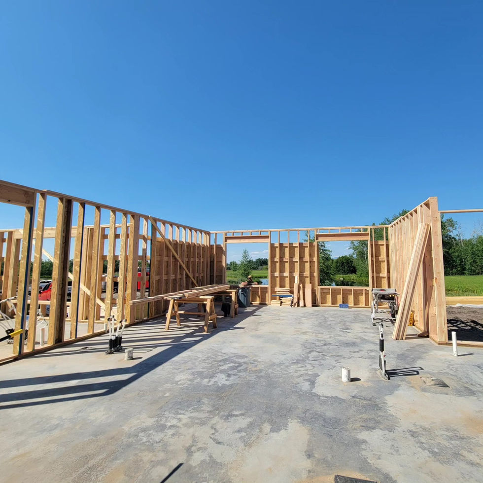 Framed interior walls dividing a Montana house slab into rooms with a saw station set up between them