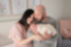 parents snuggling with their newborn girl