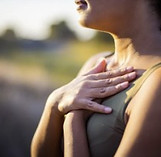 Woman holds both hands on her chest