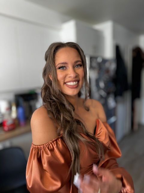 Soft glam makeup on a bridesmaid, featuring fresh glowy skin, neutral eyeshadow, and a natural pink lip, photographed indoors.