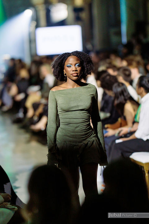 Dark skin runway model featuring radiant runway makeup and olive couture styling during the GAÏA 2026 fashion show