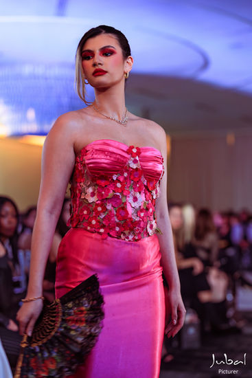 Editorial runway portrait featuring bold red makeup, glowing skin, and couture fashion styling from Hidden Couture