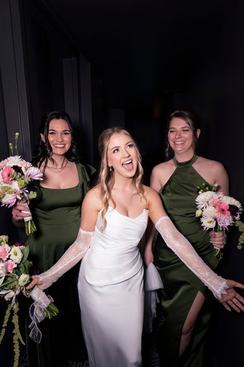 Bride celebrating with bridesmaids while wearing soft glam bridal makeup and elegant wedding styling