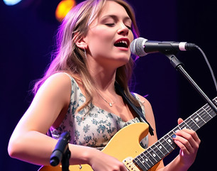 female singing and playing guitar on a s
