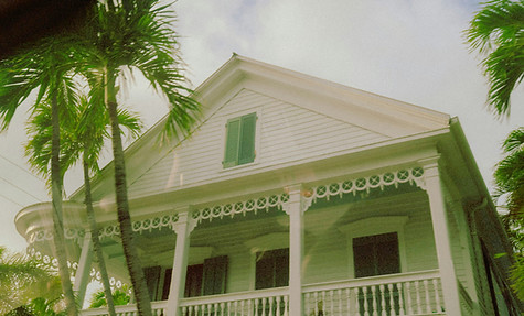 a white house with palm trees in front o