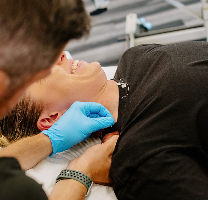 A Swift Institute specialist inserting a dry needle into the neck of a client.
