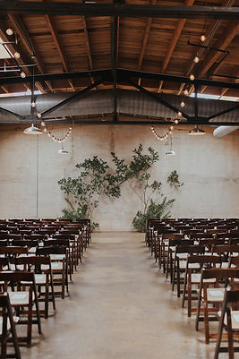 A dramatic and earthy backdrop of crepe myrtle branches frame the ceremony site at The Standard Knoxville. 