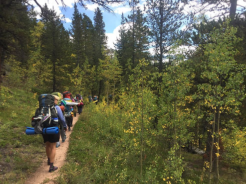 Students backpacking on voyage in the mountains