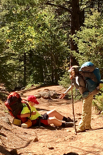 A student helping another student who fell on voyage in the mountains