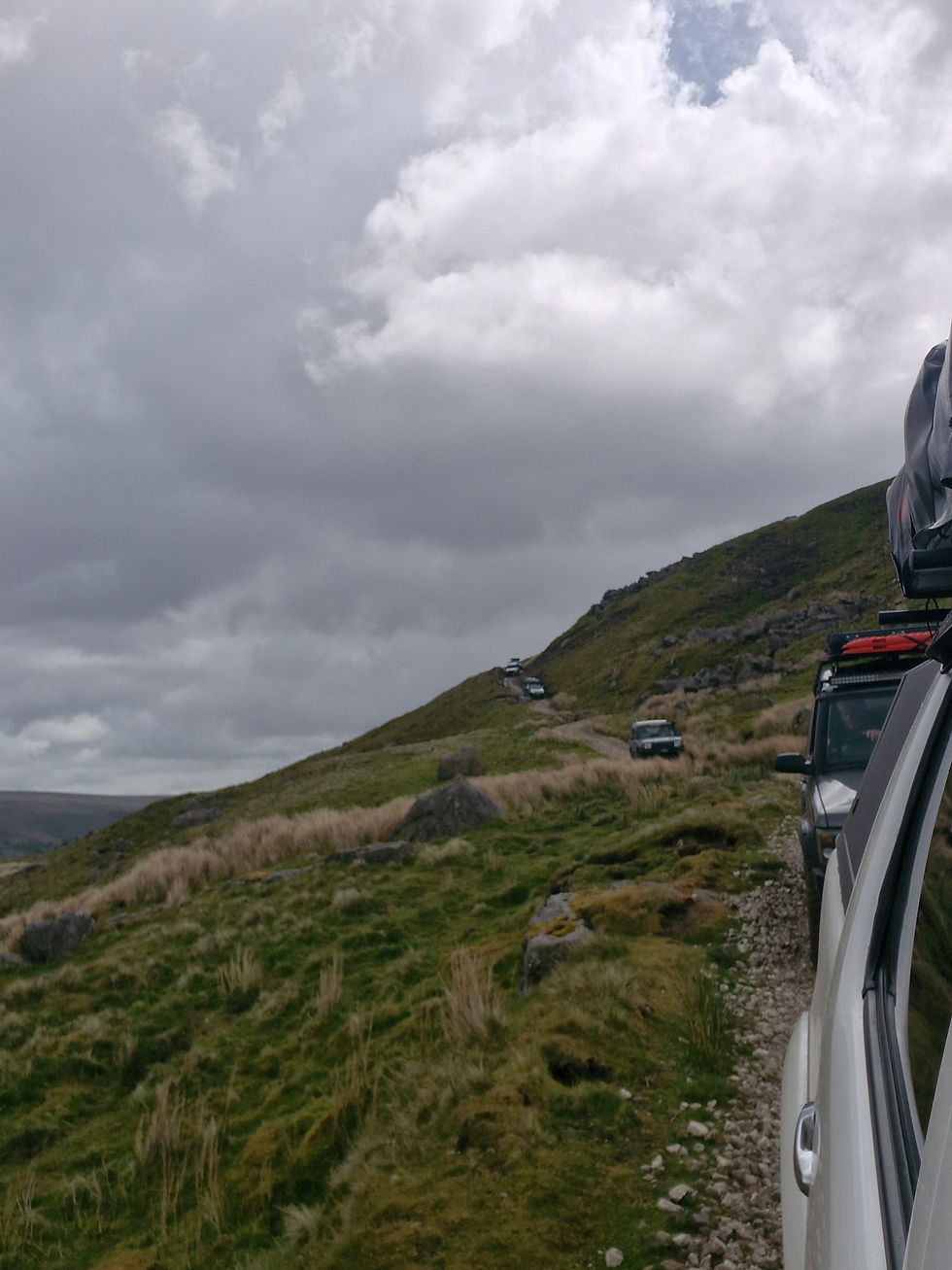 4x4 vehicle crossing open moorland under a dramatic sky on a guided 4x4 tour in Wales
