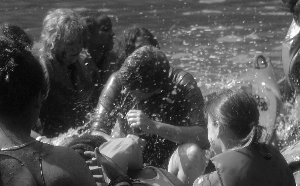 Camp waterfront with swimmers and lifeguard supervision