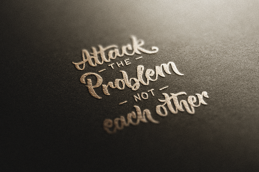 Stylish calligraphy of the phrase "attack The Problem Not Each Other," featuring a flowing script.