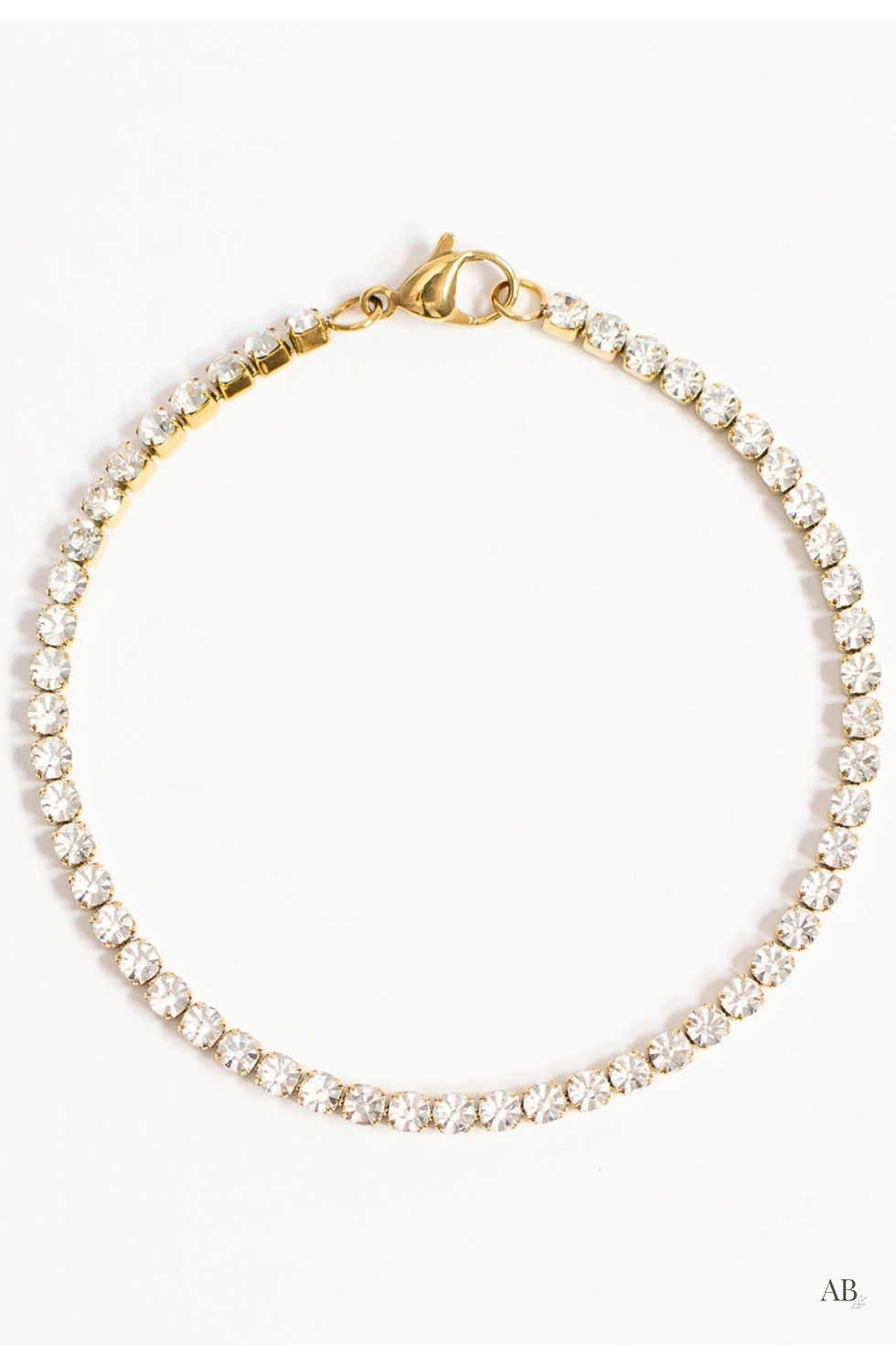Waterproof 18k gold PVD tennis bracelet featuring a continuous line of brilliant cubic zirconia stones flat layout.
