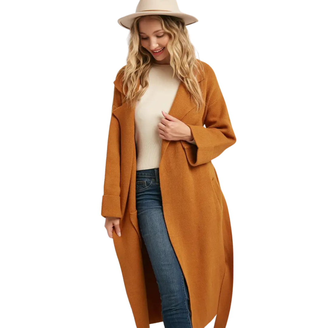 Woman wearing a camel belted trench coat with lapel collar, styled with jeans and ankle boots, front view.