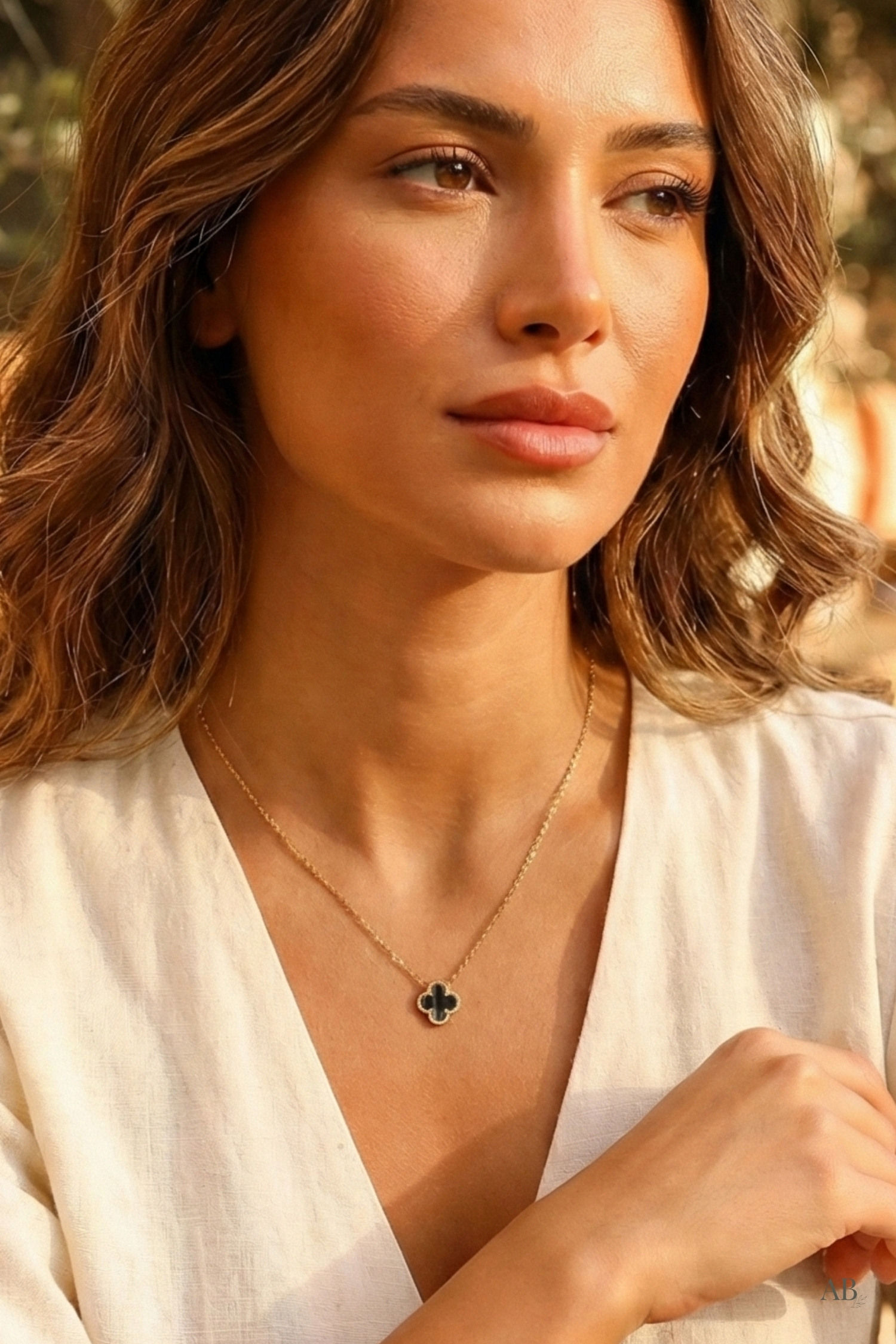 Model wearing a waterproof gold necklace with a black clover pendant from a Michigan boutique.