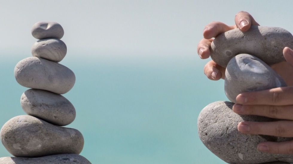 A child's hands piling up rocks representing a superannuation recontribution strategy