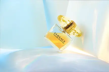 "Versace Yellow Diamond perfume bottle with harsh sunlight streaming from the corners of a white box - captured by Spinthiras Media's professional product photography."






