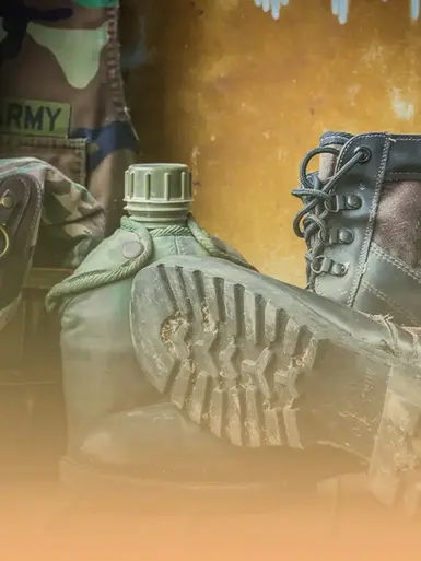 Military uniform with "ARMY" text, green canteen, and boot on ground.