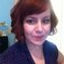 Woman with short reddish-brown hair looking directly at camera.