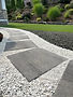 Stepping stones pathway through white gravel and lawn.