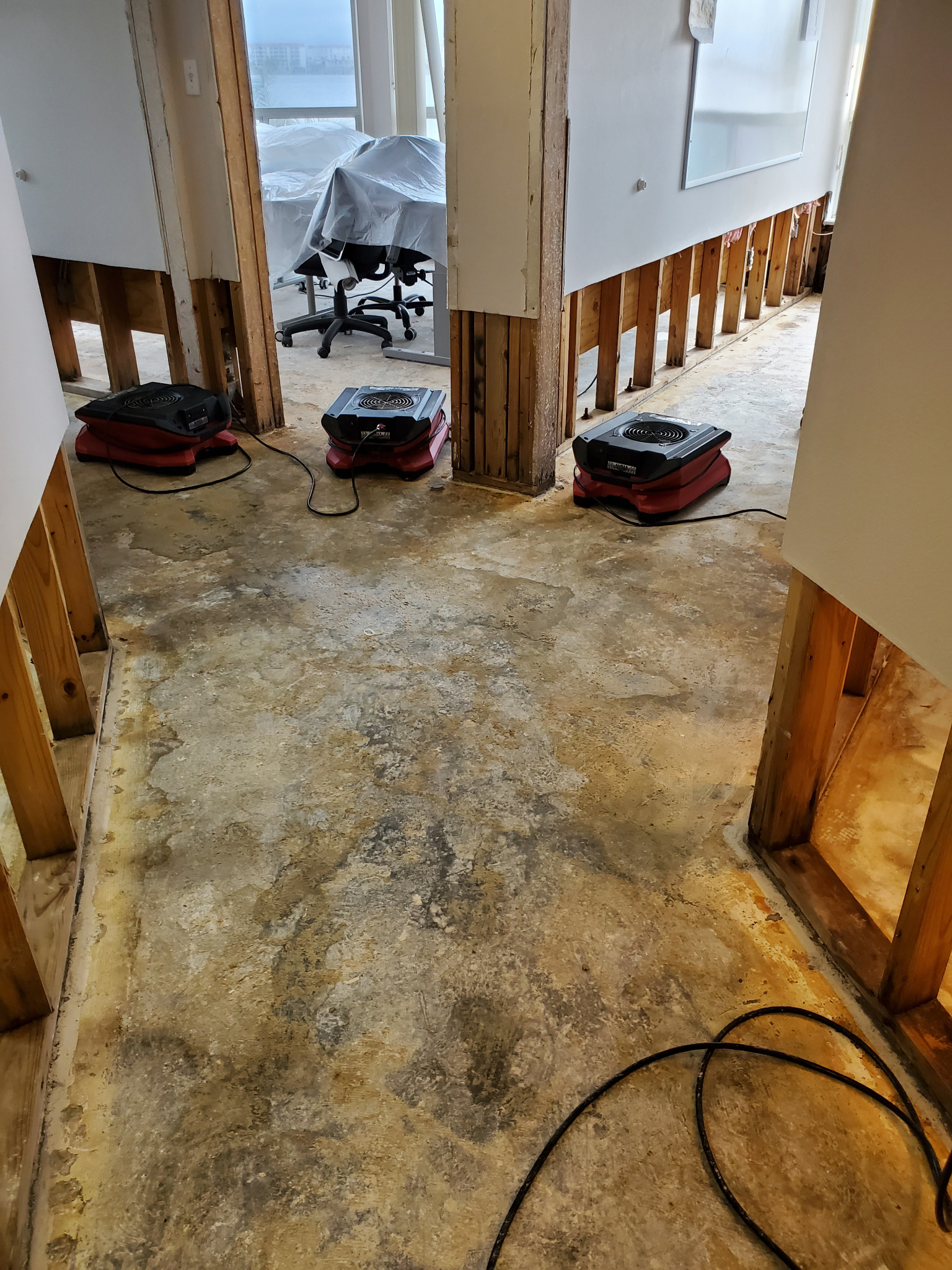 Interior after water-damaged wall material removal, with drying equipment