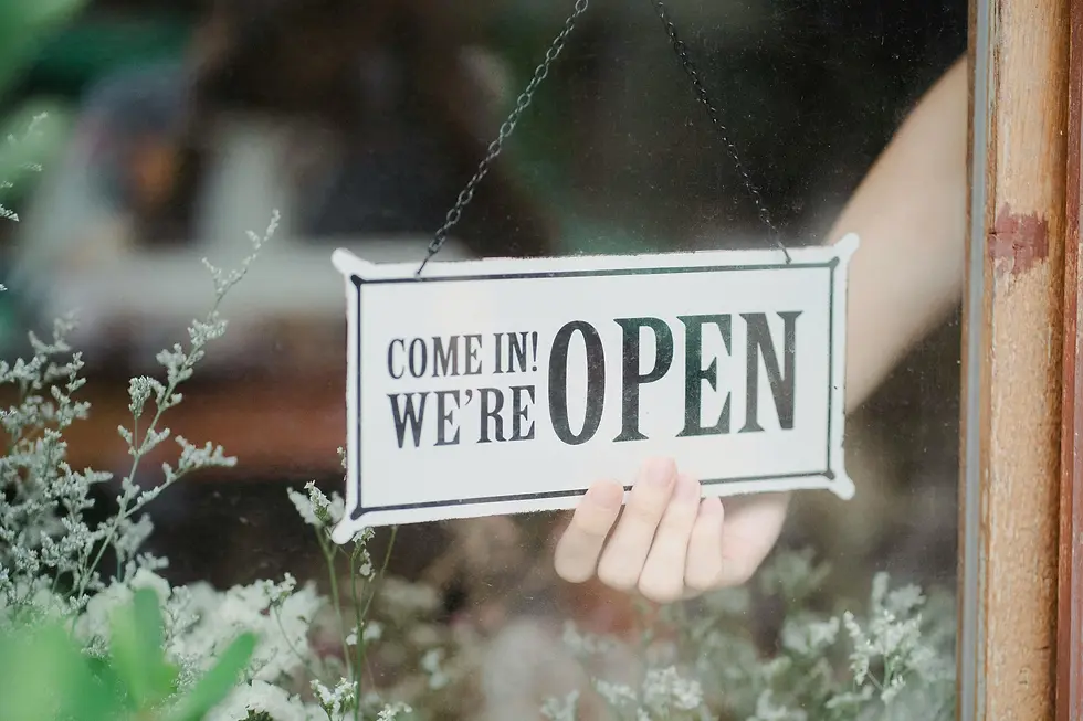 Close-up of an open sign hanging on a shop door.