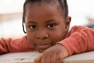 Black child in burnt orange long sleeve shirt in empathy article for PlayfulLeigh Psyched