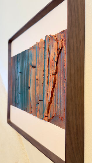 a painting in a wooden frame is hanging on a wall