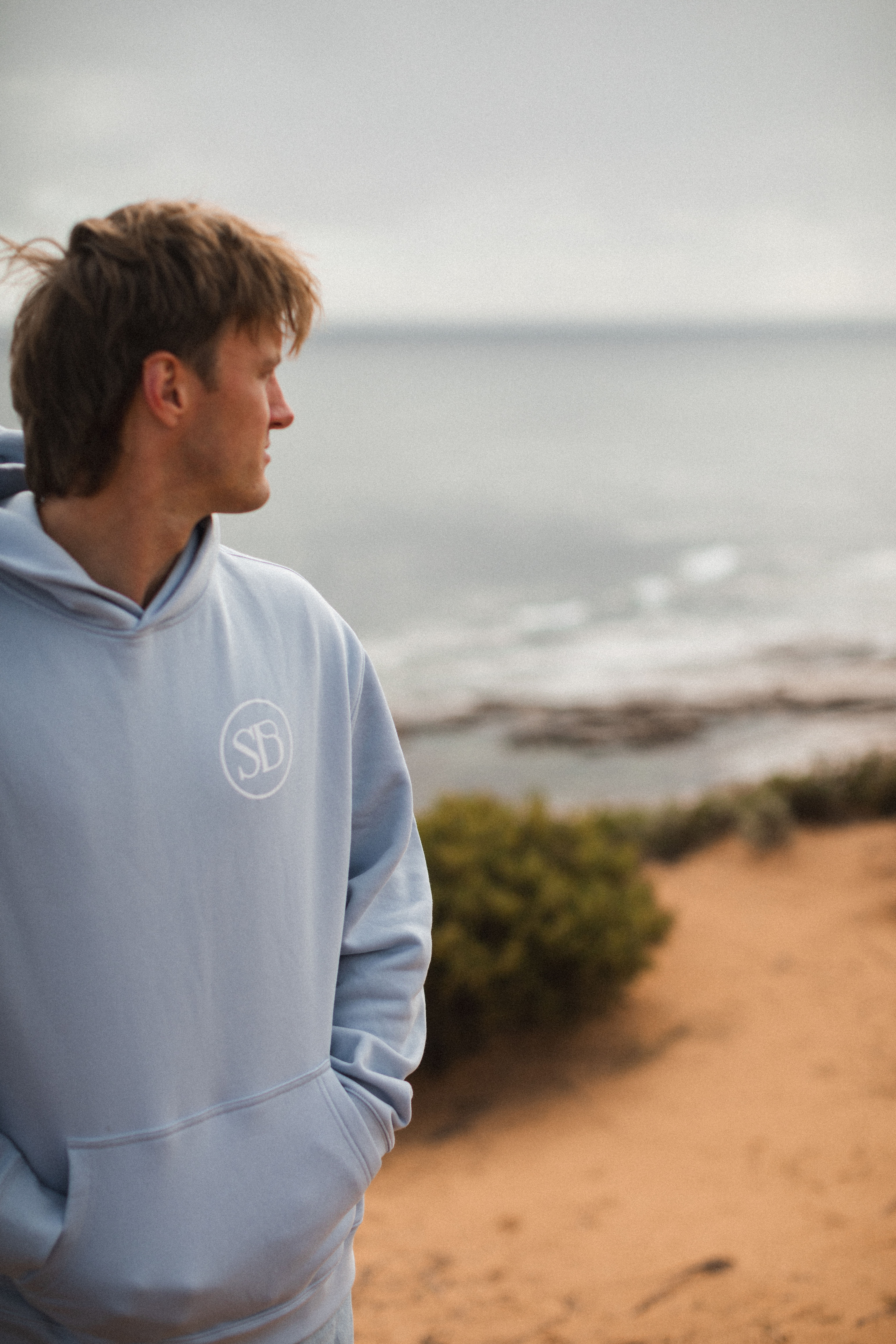 Sam wearing the Blue hoodie with the SB logo, overlooking the pools at Smooth Pool