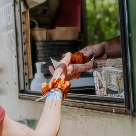 handing out an order of tots at an event