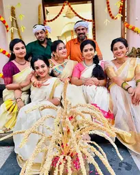 Surya TV family in kasavu Kerala sarees, setmundu, and kasavu mundu with kurtas, celebrating Onam festival for a show.