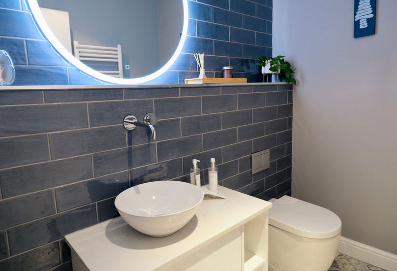 small family bathroom with blue subway tiles and white furniture