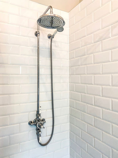 large walk in shower with white subway tile wall