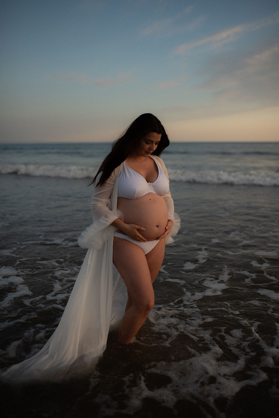Pregnant mother in the sea at blue hour