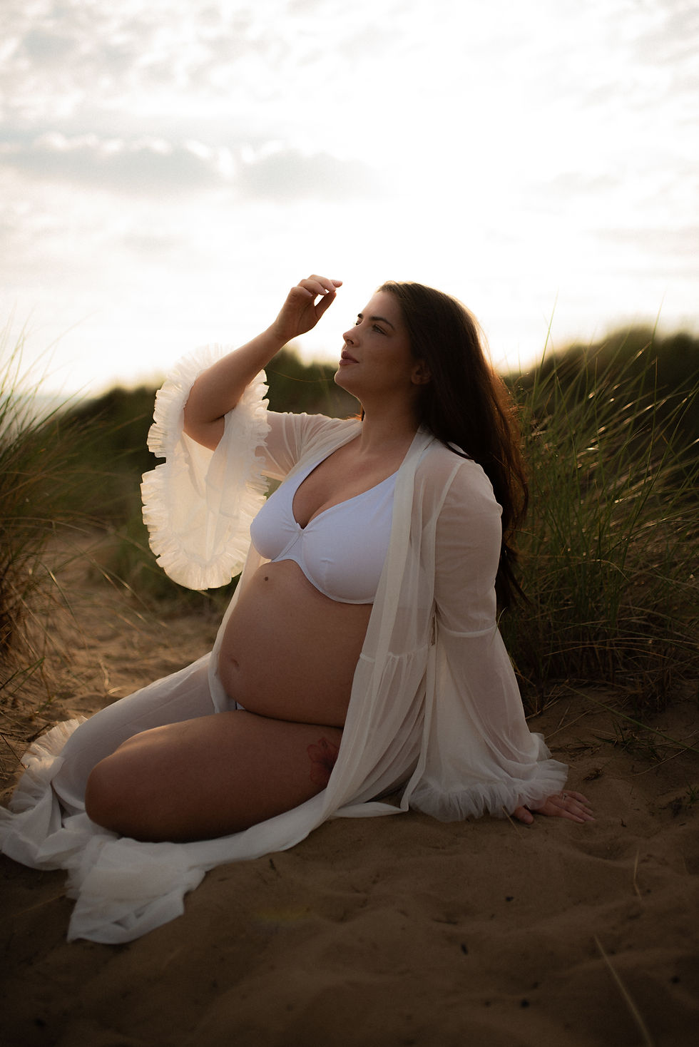 A pregnant mother sat on the sand