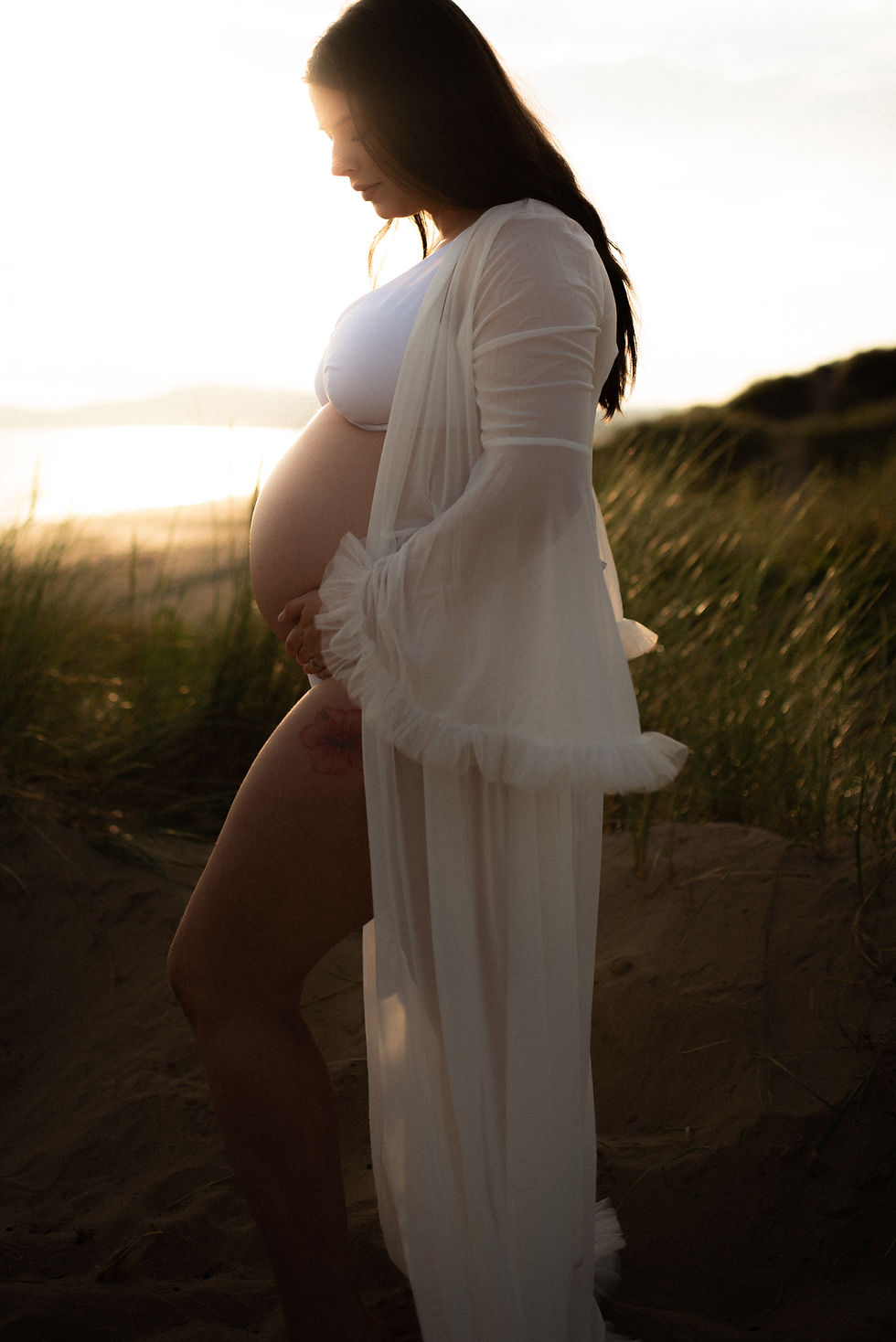 A pregnant mother holding and looking at pregnant belly