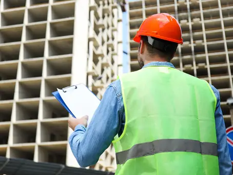 Ingénieur BTP avec casque et gilet fluorescent contrôlant un chantier de démolition à Paris