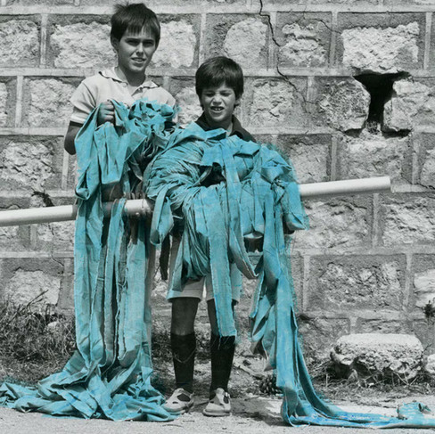 Bambini del paese di Ulassai in Sardegna che reggono il nastro azzurro per la performance di Maria Lai.